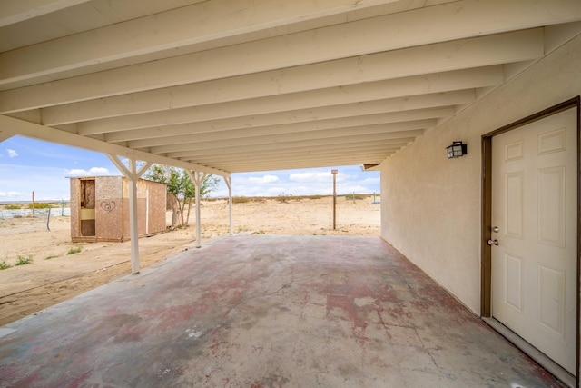 view of patio / terrace with an outdoor structure, a storage shed, and a carport