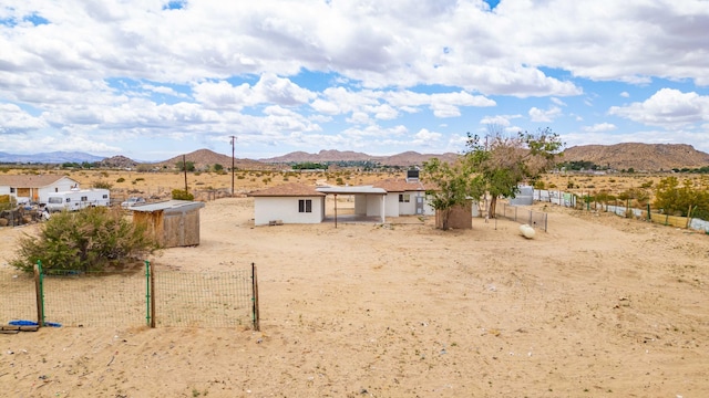 rear view of property featuring a mountain view and fence