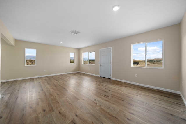 unfurnished living room featuring visible vents, wood finished floors, baseboards, and recessed lighting
