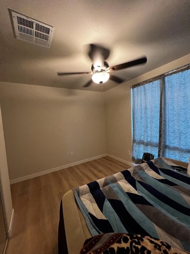 unfurnished bedroom with ceiling fan and wood-type flooring