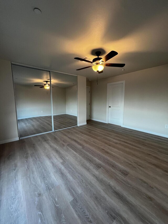 unfurnished bedroom with ceiling fan and dark hardwood / wood-style flooring