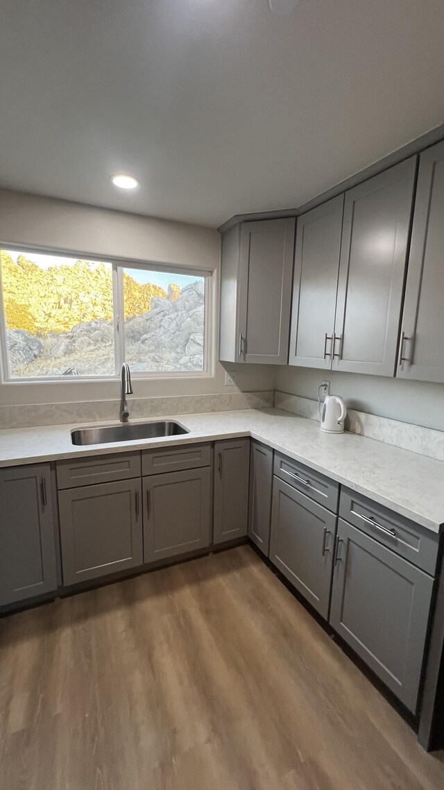 kitchen featuring dark wood-type flooring, gray cabinetry, and sink