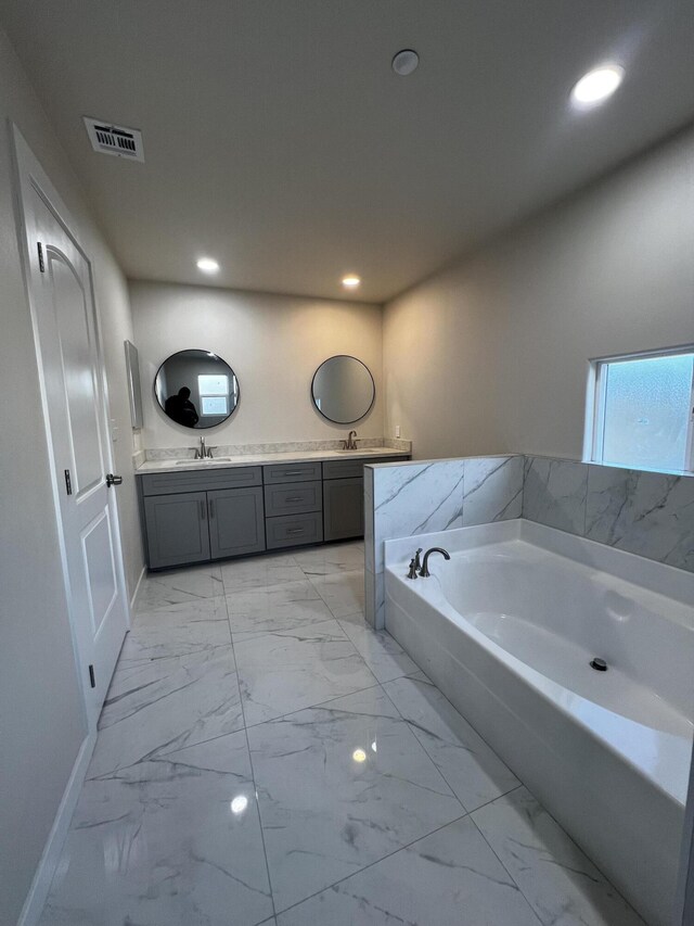 bathroom with vanity and a bath