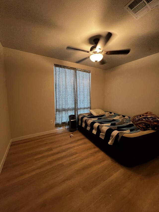 bedroom with hardwood / wood-style floors and ceiling fan