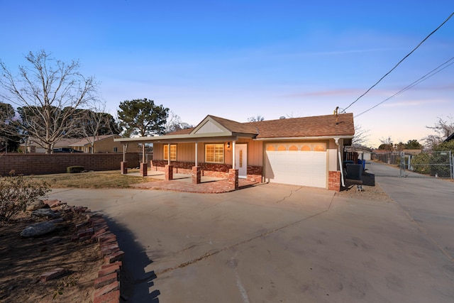 single story home featuring a garage, central AC unit, and covered porch