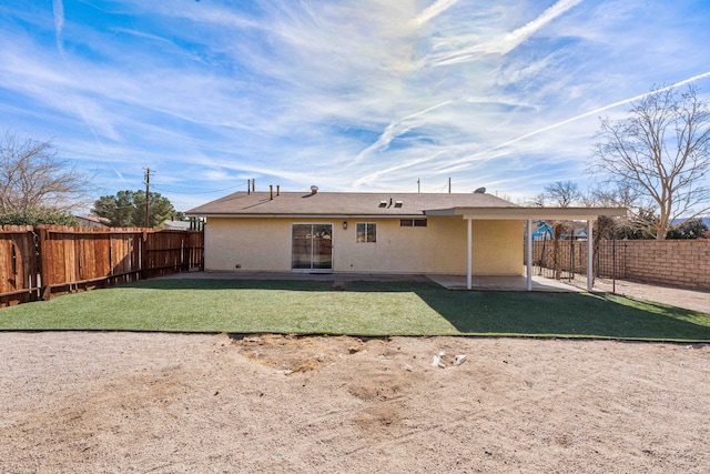 rear view of property featuring a yard and a patio area