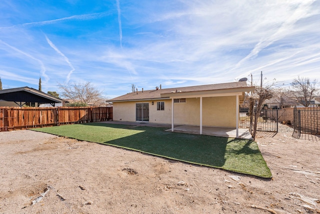 back of property featuring a yard and a patio area