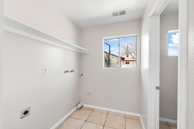 clothes washing area featuring hookup for a gas dryer, hookup for an electric dryer, and light tile patterned floors