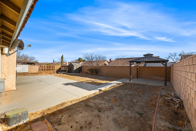 view of yard featuring a gazebo, a patio area, and a storage shed