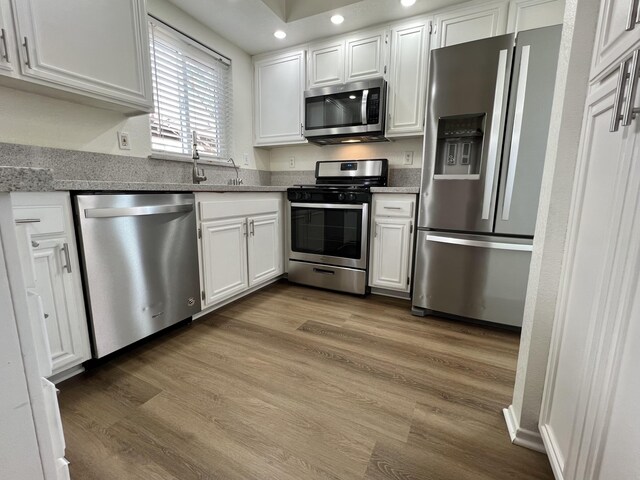 kitchen with white cabinetry, sink, and stainless steel appliances