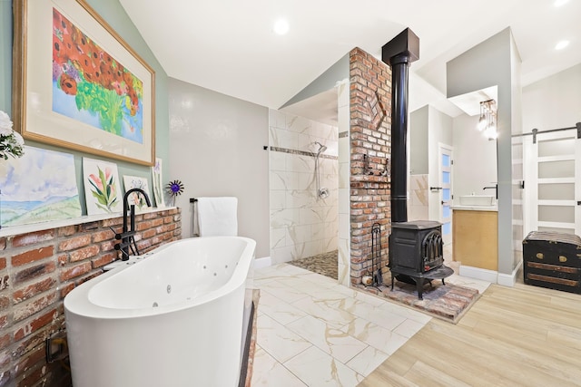 bathroom featuring a freestanding tub, baseboards, walk in shower, a wood stove, and vaulted ceiling