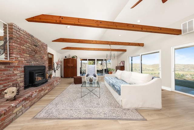 living room featuring lofted ceiling with beams, visible vents, a wealth of natural light, and ceiling fan