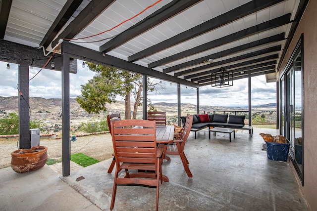 view of patio with a mountain view, outdoor dining area, and outdoor lounge area