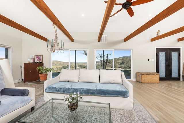 living room featuring visible vents, beam ceiling, wood finished floors, baseboards, and ceiling fan