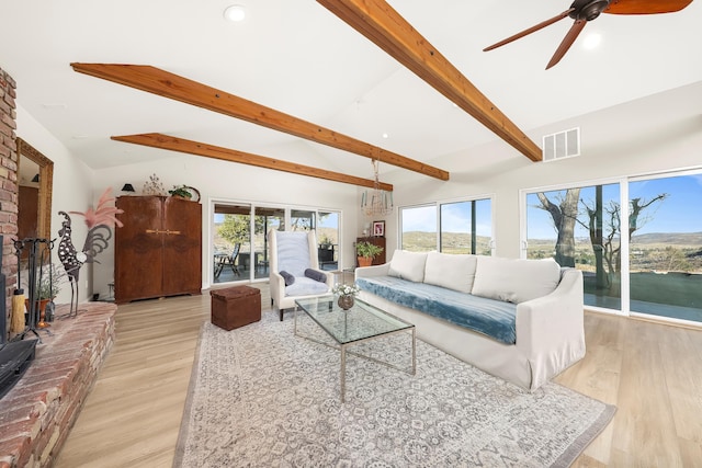 living area featuring visible vents, plenty of natural light, a ceiling fan, and vaulted ceiling with beams