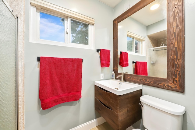 bathroom featuring vanity, a shower stall, and toilet