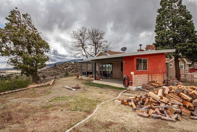 rear view of property featuring a patio and a mountain view