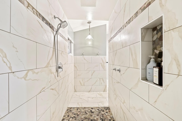 bathroom featuring visible vents, tile walls, and tiled shower