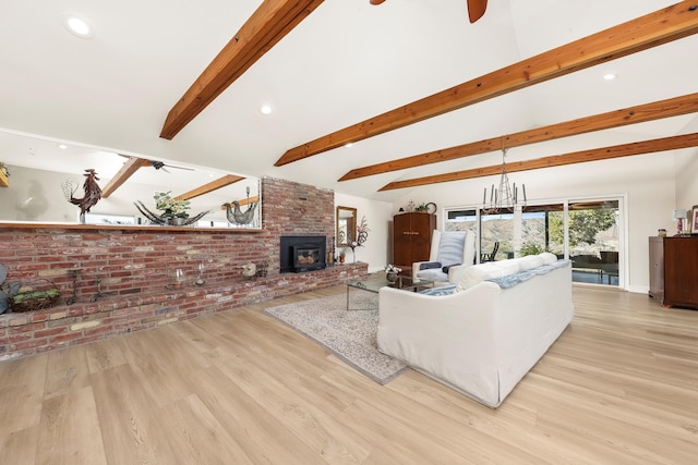 living room with beamed ceiling, a ceiling fan, wood finished floors, brick wall, and a fireplace