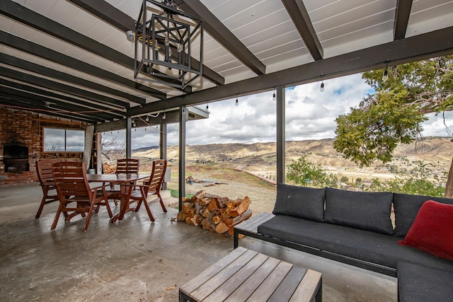 sunroom with beam ceiling and a mountain view