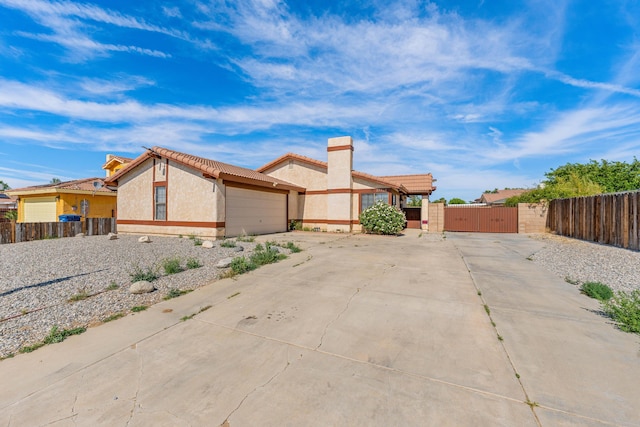37756 E 45th St, Palmdale, CA 93552 - view of property exterior featuring a gate, concrete driveway, stucco siding, a tiled roof, and a garage