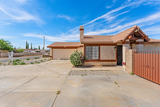 37756 E 45th St, Palmdale, CA 93552 - view of front facade featuring a tiled roof, an attached garage, driveway, stucco siding, and a chimney