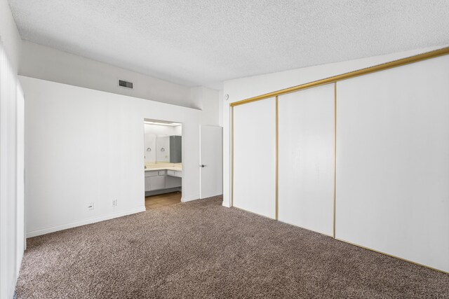37756 E 45th St, Palmdale, CA 93552 - unfurnished bedroom featuring carpet, a textured ceiling, a closet, and connected bathroom