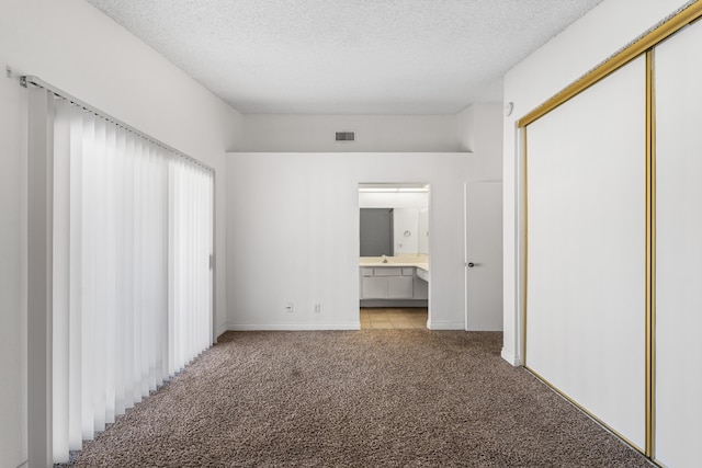 37756 E 45th St, Palmdale, CA 93552 - unfurnished bedroom featuring light colored carpet, a textured ceiling, a closet, ensuite bathroom, and baseboards
