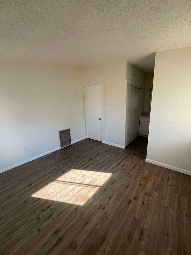 spare room with dark hardwood / wood-style flooring and a textured ceiling