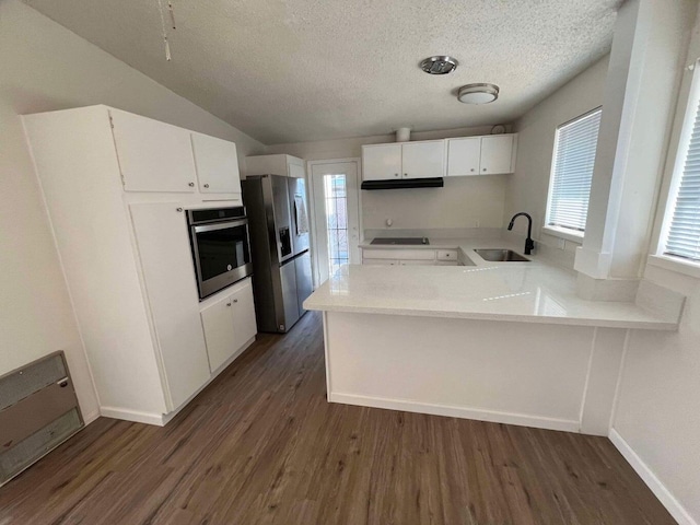 kitchen with sink, white cabinetry, dark hardwood / wood-style flooring, kitchen peninsula, and stainless steel appliances