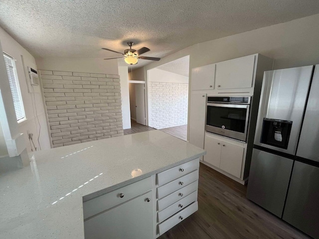 kitchen with light stone counters, stainless steel appliances, dark hardwood / wood-style floors, and white cabinets