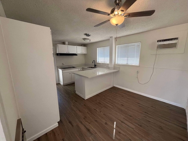 kitchen featuring dark hardwood / wood-style floors, white cabinetry, sink, black electric stovetop, and kitchen peninsula