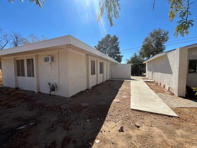 view of side of home with an AC wall unit