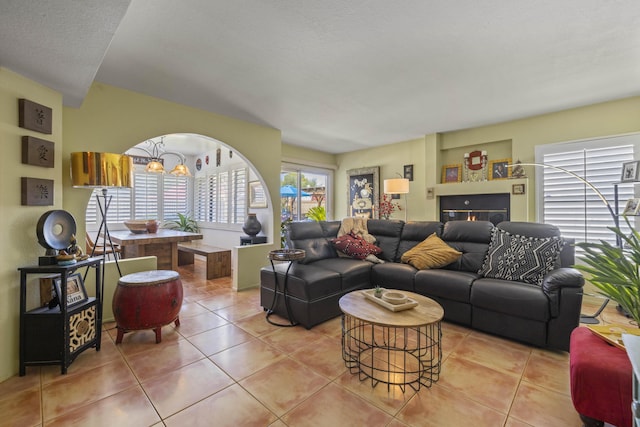 tiled living room with an inviting chandelier and a textured ceiling