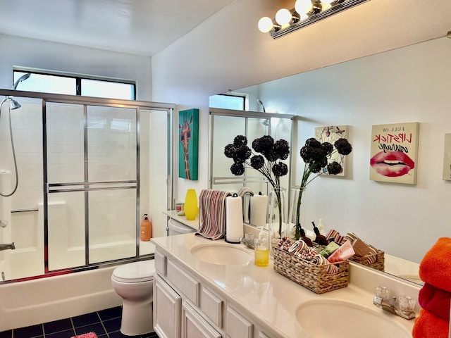 full bathroom with toilet, vanity, bath / shower combo with glass door, and tile patterned flooring