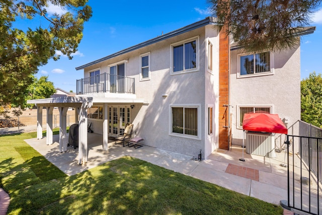 back of property featuring french doors, a pergola, a balcony, a patio, and a yard