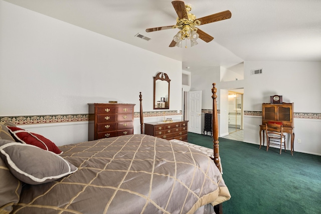 bedroom with ceiling fan, ensuite bathroom, dark carpet, and lofted ceiling