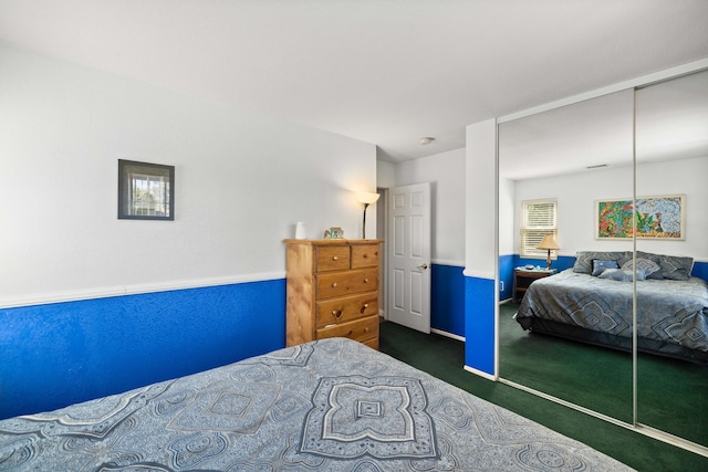 bedroom with dark carpet and a closet