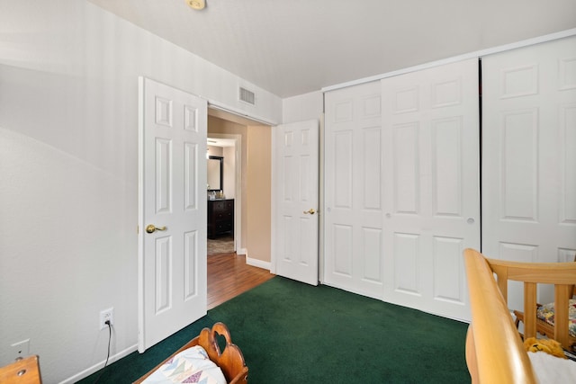 bedroom with dark carpet and a closet