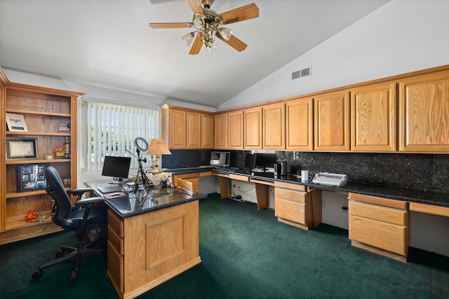 carpeted home office with ceiling fan, built in desk, and lofted ceiling