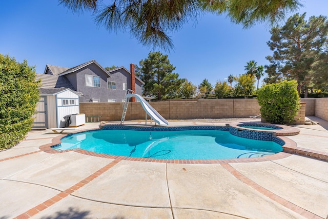 view of swimming pool featuring an in ground hot tub, a patio, a diving board, and a water slide