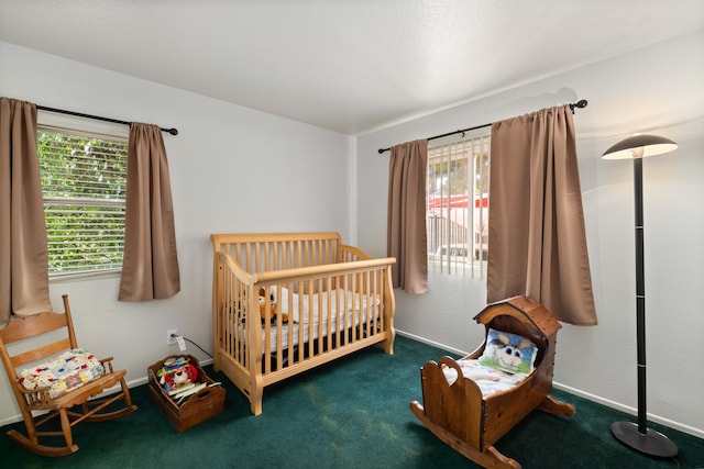 bedroom featuring dark colored carpet and a nursery area