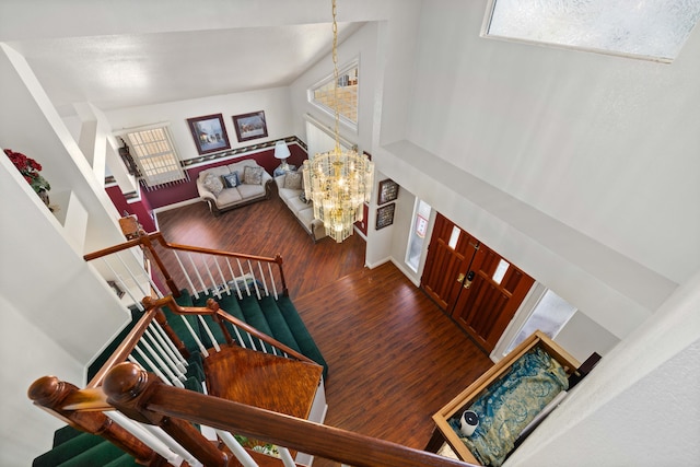 entryway with a notable chandelier, dark wood-type flooring, and a high ceiling