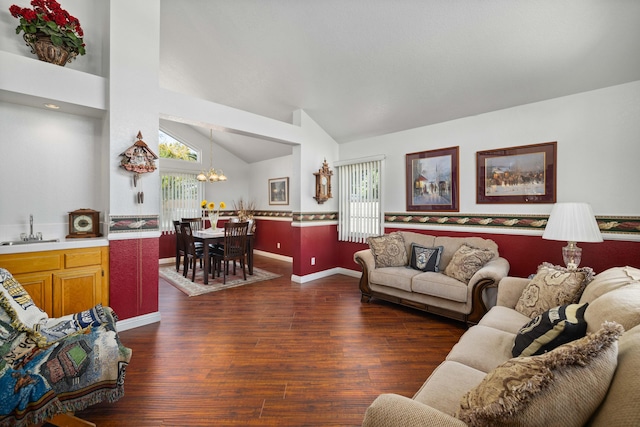 living room with a wealth of natural light, sink, dark hardwood / wood-style floors, and a notable chandelier