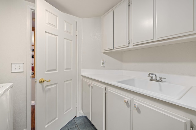 laundry area with sink and dark tile patterned floors