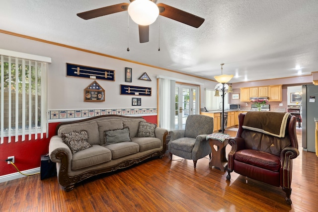 living room featuring hardwood / wood-style floors, crown molding, and a textured ceiling