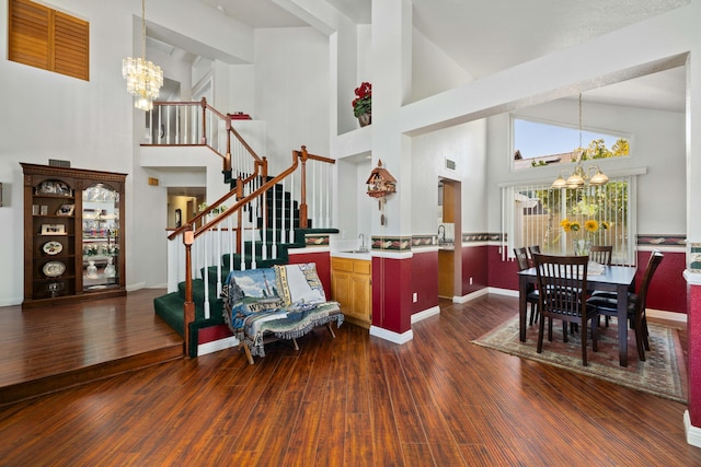 entrance foyer with sink, dark hardwood / wood-style floors, a high ceiling, and an inviting chandelier