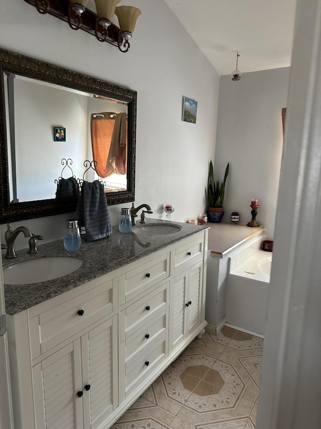 bathroom with tile patterned floors, a washtub, vanity, and vaulted ceiling