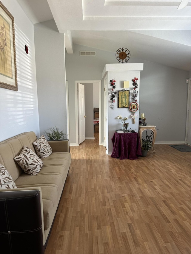 living room featuring hardwood / wood-style flooring and vaulted ceiling