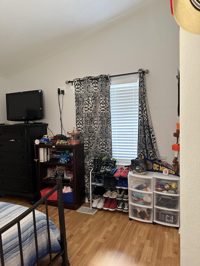 bedroom featuring hardwood / wood-style floors and lofted ceiling